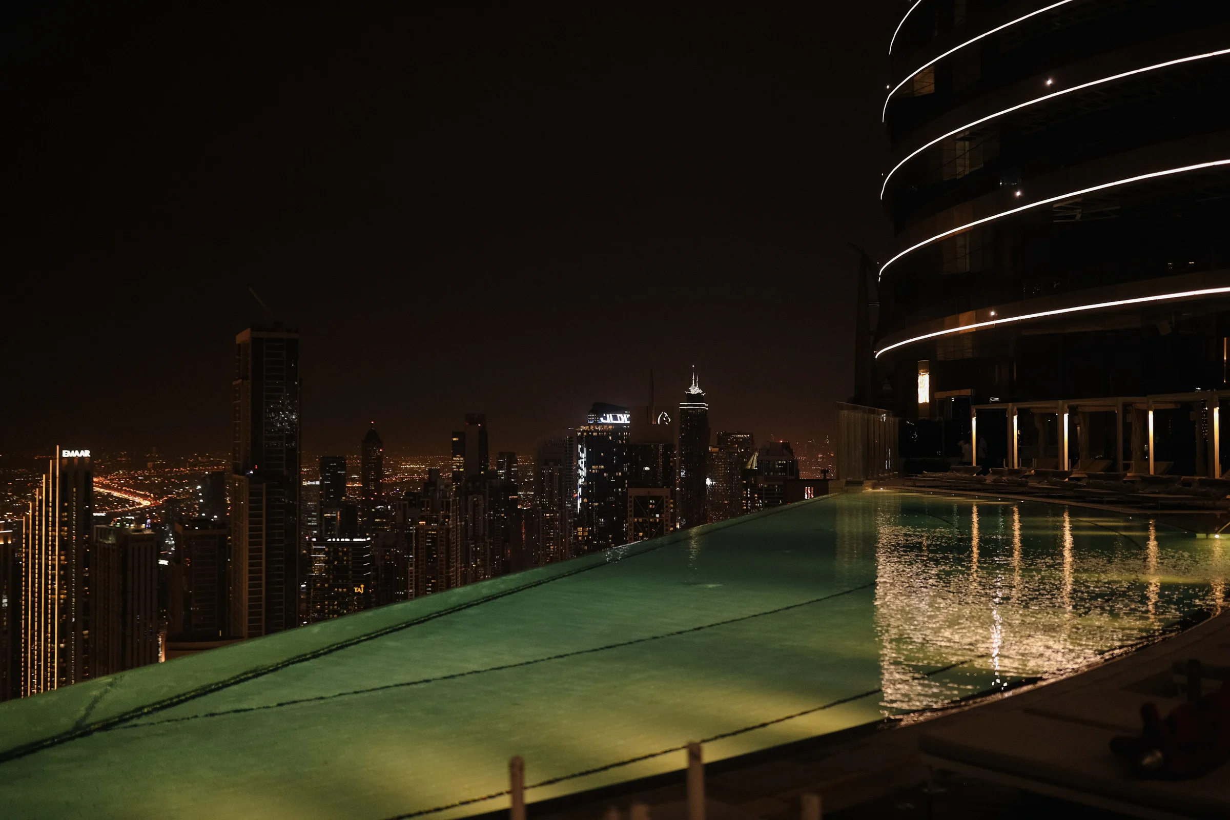 Basen na dachu z nocną panoramą Dubaju